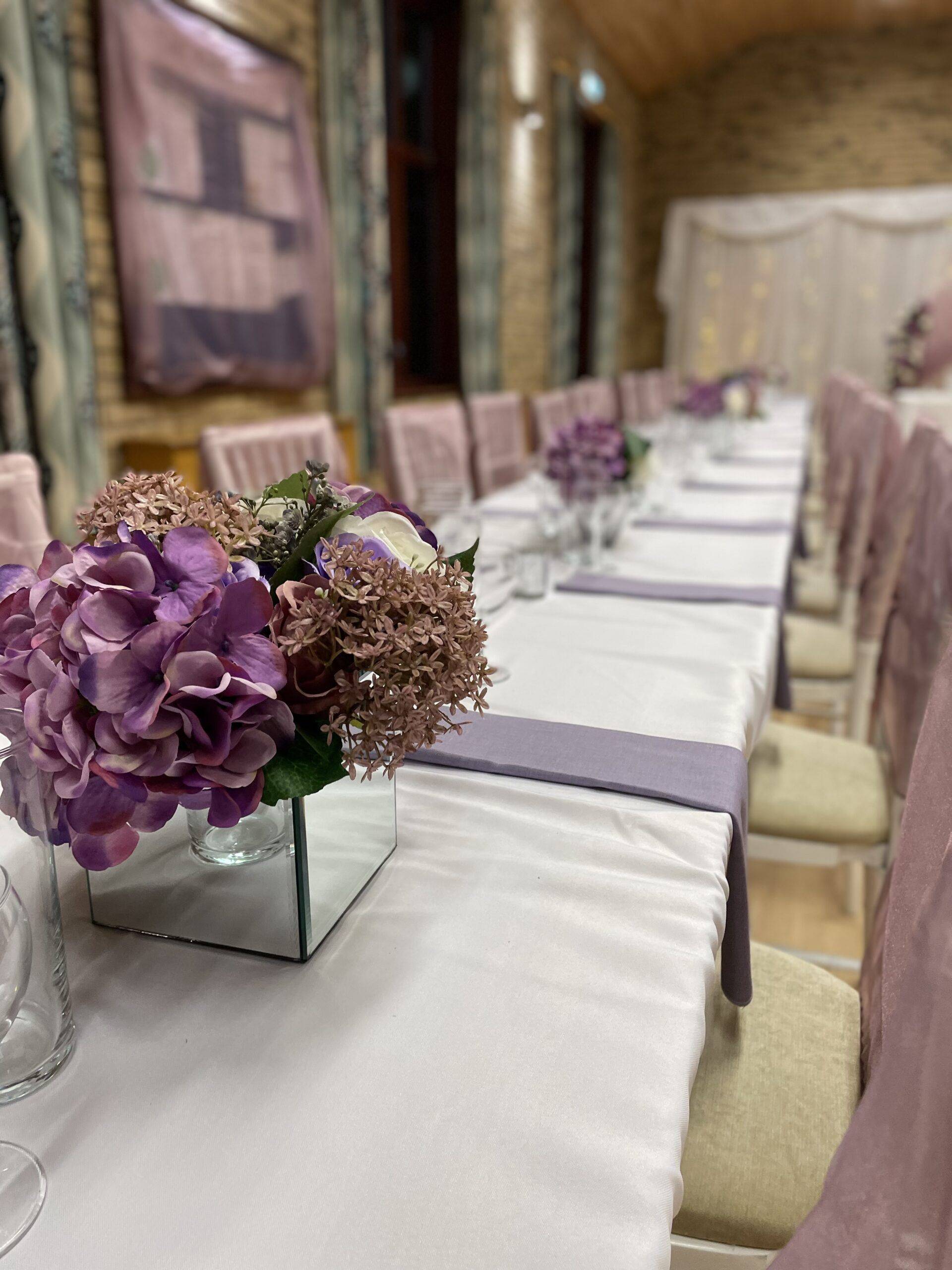a long table with a vase of flowers on it.