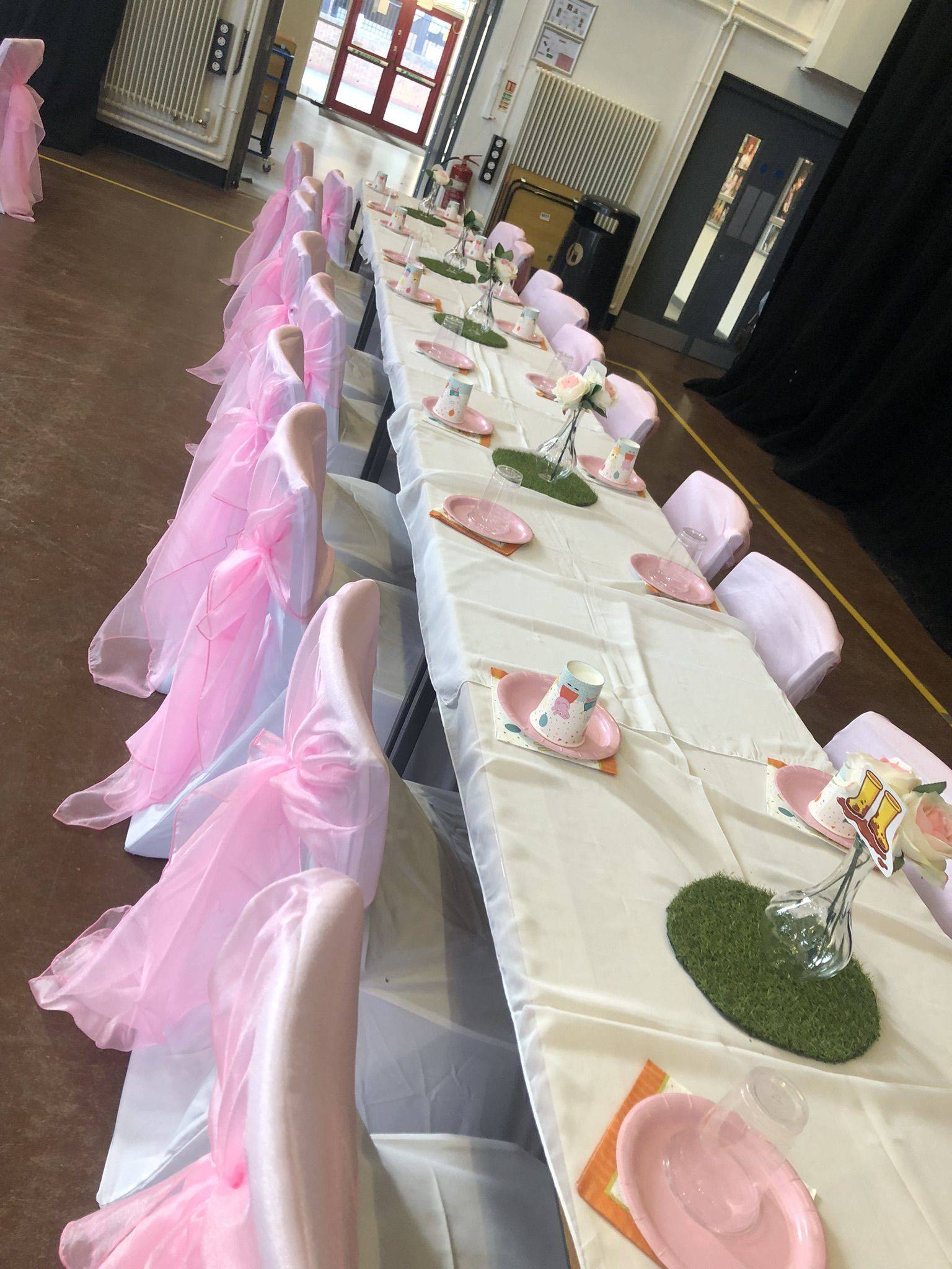 a long table with pink and white table cloths.