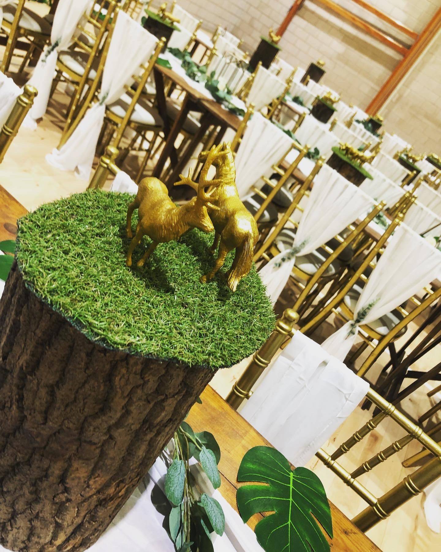 a wooden table topped with a fake horse on top of a lush green field.