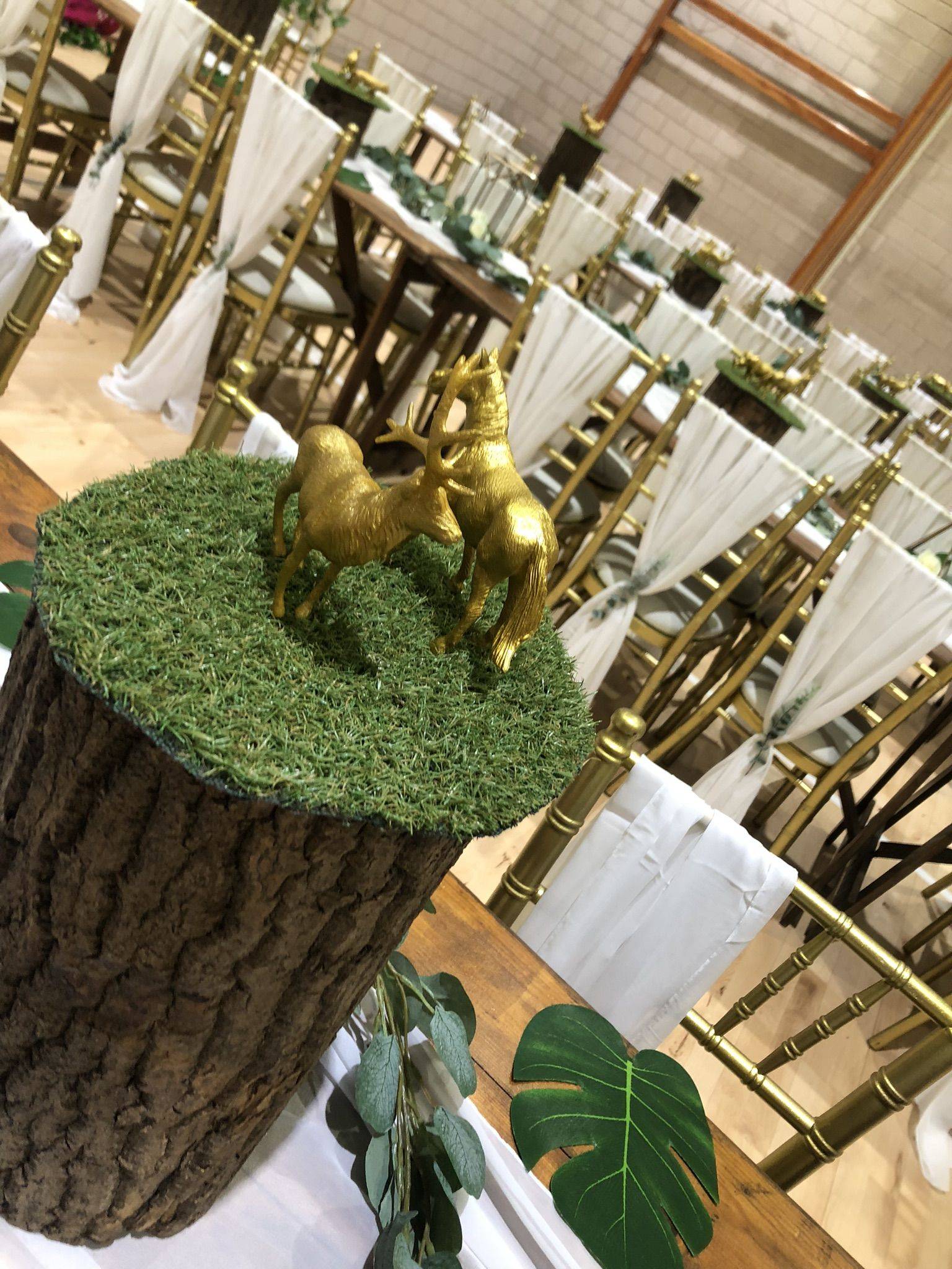 a table topped with a tree stump covered in fake grass.