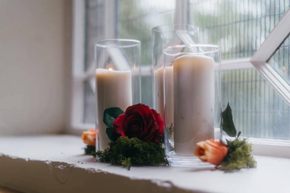 a couple of candles sitting on top of a window sill.