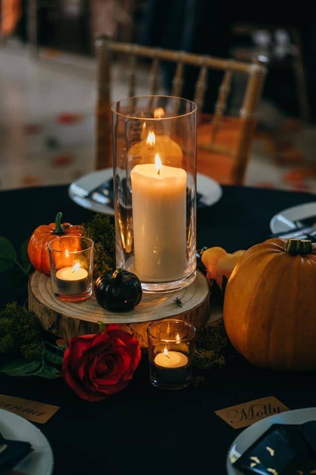 a table topped with candles and pumpkins on top of a table.