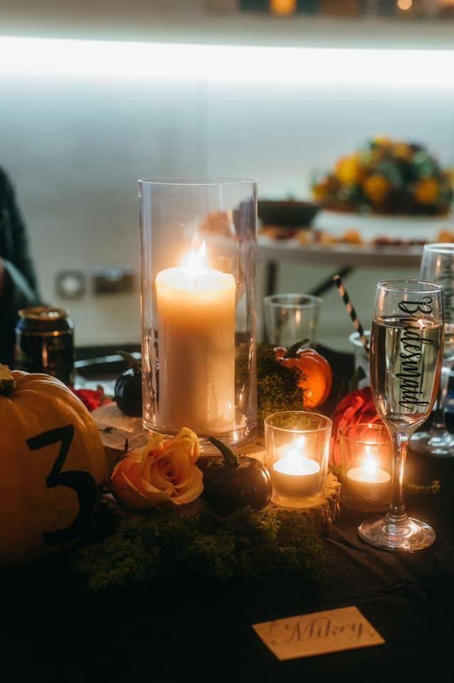 a table topped with candles and pumpkins.