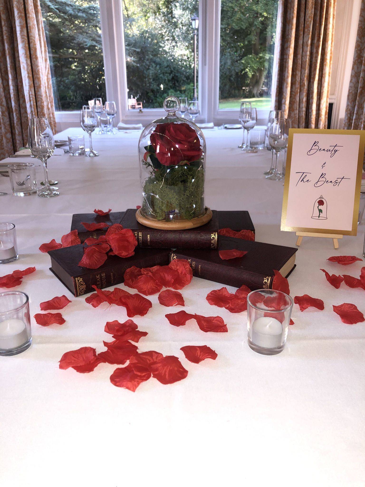 a table with rose petals and a book.