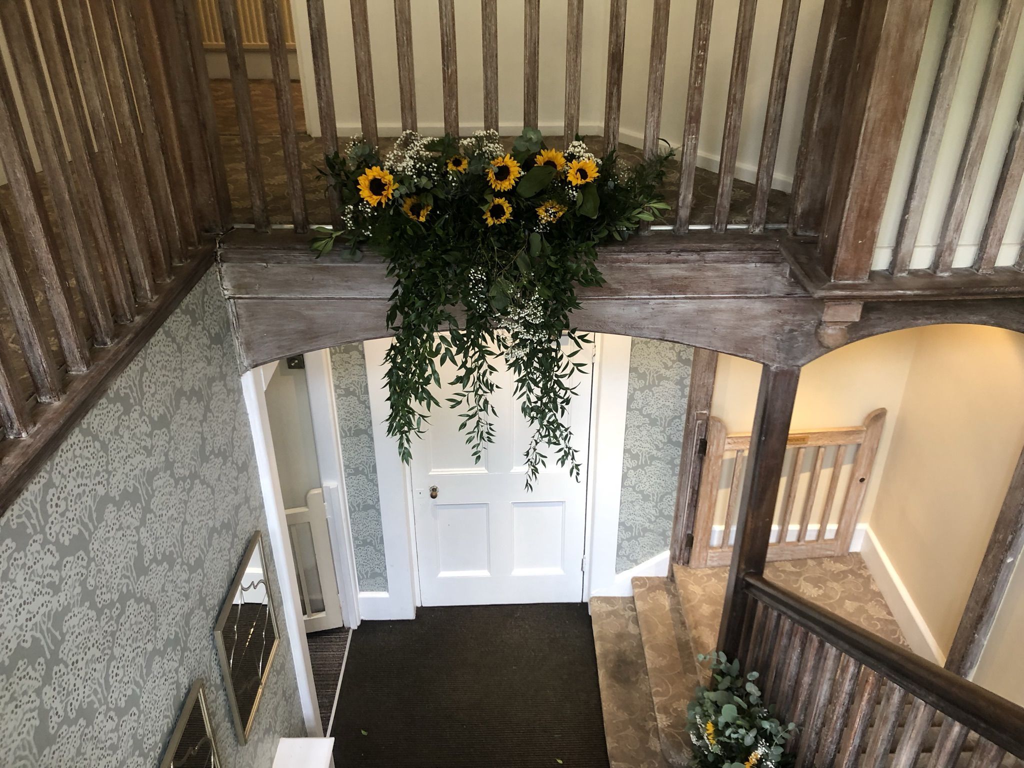 a staircase with flowers hanging from the ceiling.