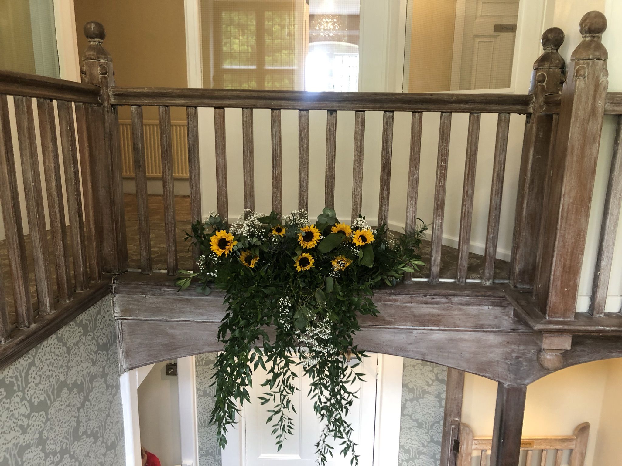 a bunch of sunflowers are hanging from a railing.