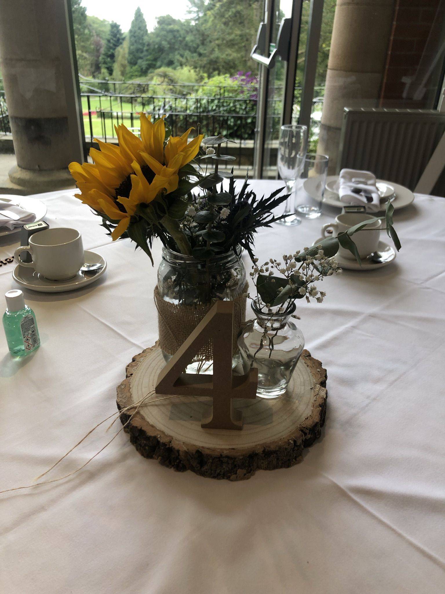 a table topped with a vase filled with yellow flowers.