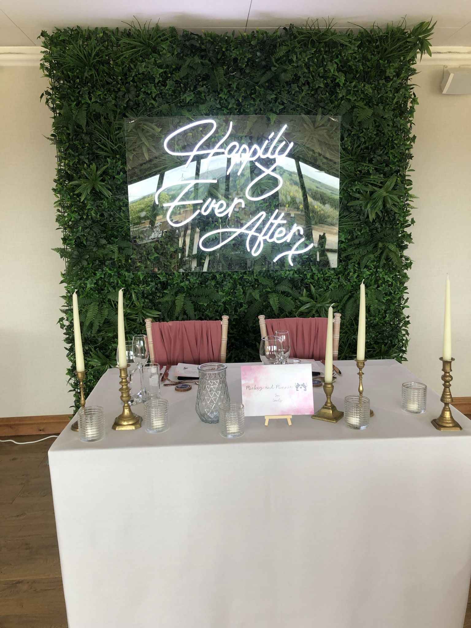 a white table topped with candles and a sign.